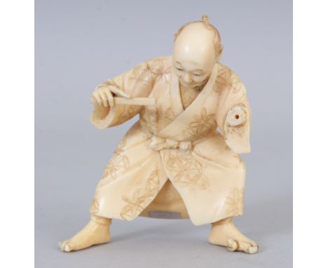 A SMALL SIGNED JAPANESE MEIJI PERIOD IVORY OKIMONO OF A STANDING MAN, holding a stick, the base with an engraved signature on