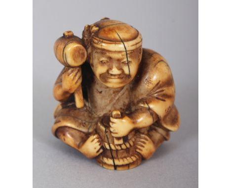 A JAPANESE MEIJI PERIOD STAINED IVORY NETSUKE OF A SEATED ARTISAN, wielding a mallet, 1.3in high.