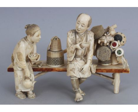 A GOOD QUALITY SIGNED JAPANESE MEIJI PERIOD SECTIONAL IVORY OKIMONO OF A BASKET &amp; DRUM SELLER &amp; HIS WIFE, weighing ap