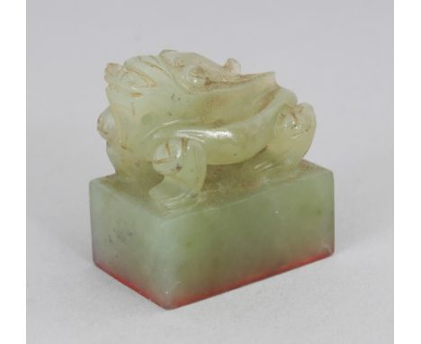 A SMALL 20TH CENTURY CHINESE CELADON JADE RECTANGULAR SEAL, surmounted by a dragon, 1.2in x 0.75in x 1.25in high.