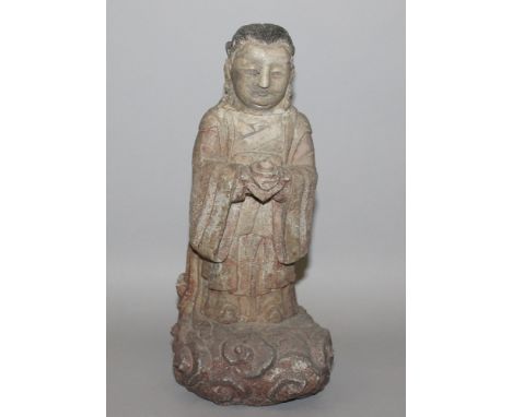 AN UNUSUAL CHINESE CARVED STONE FIGURE OF A BODHISATTVA, rendered standing on a cloud scroll plinth in flowing robes and bear