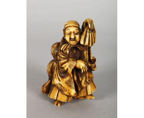 A JAPANESE MEIJI PERIOD STAINED IVORY NETSUKE OF A DANCER &amp; HIS SON, the man holding an upturned fan, 2.9in high.