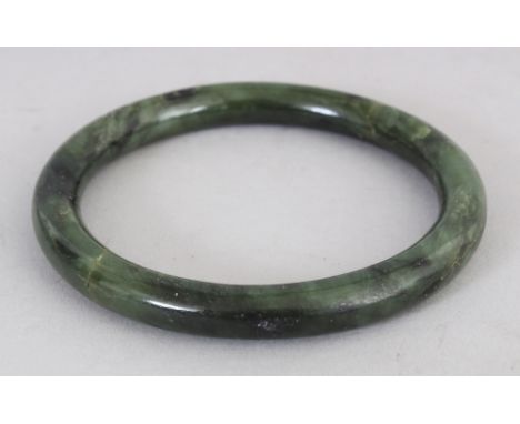 A CHINESE SPINACH GREEN JADE BANGLE, 3.3in diameter, the inner rim 2.5in diameter.