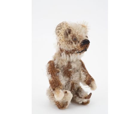 A 1930s Schuco Piccolo miniature Teddy bear, having articulated limbs with felt paws and feet, golden mohair, steel button ey