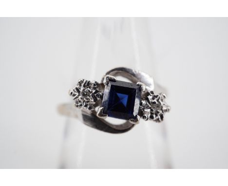 A sapphire and diamond twist set dress ring with central princess cut sapphire of approximately .47ct, flanked by illusion-se