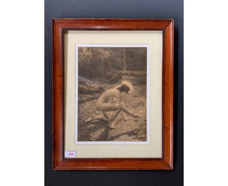 A 19th Century nude photograph of a young lady crouching to pick a daisy, ambrotype, with flower picked out in paint, from th