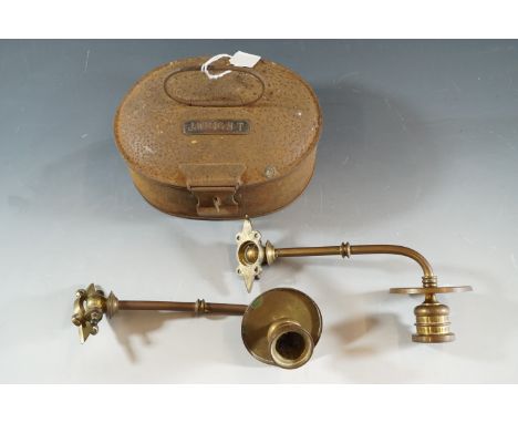 A pair of brass candle sconces and a vintage tin 