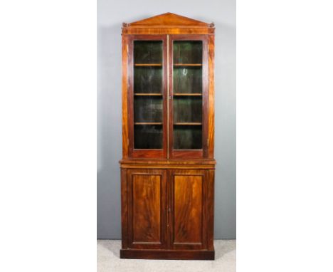 An early Victorian mahogany bookcase, the upper part with angled pediment, fitted three shelves enclosed by a pair of glazed 