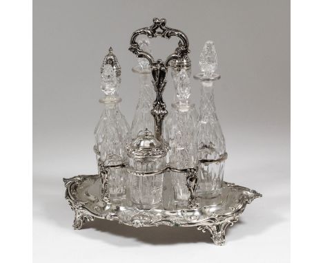 A Victorian silver oval seven division cruet stand with cast leaf scroll capped loop centre handle, the shaped and moulded ba