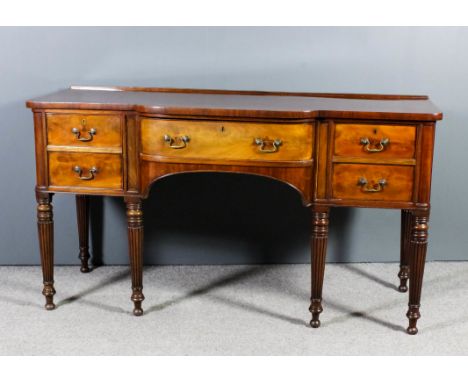 A late Georgian mahogany bow and break-front sideboard, fitted one central drawer flanked by cupboard and deep drawer each wi