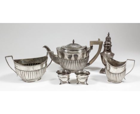 An Edward VII silver oval three piece tea service with part reeded bodies and angular loop handles, comprising - teapot with 