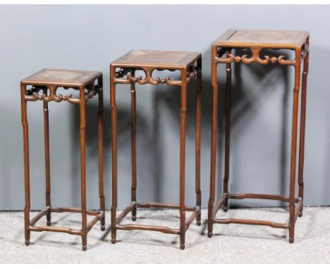 A nest of three 20th Century Chinese rosewood square stacking tables with flush pattern tops, fretted and carved scroll apron