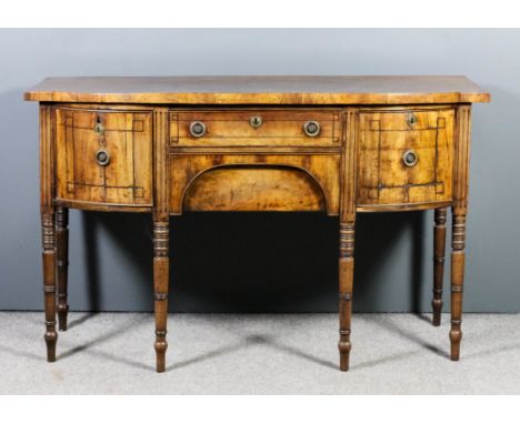 A George III mahogany bow and break-front sideboard inlaid with ebonised stringings, fitted two central drawers flanked by de