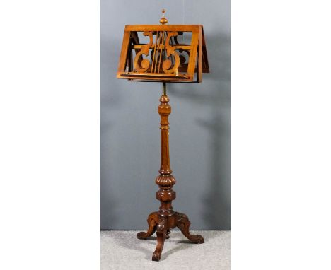 A late Victorian walnut "Duet" music stand the adjustable double sided musuc stand with fretted lyre pattern back, on turned,