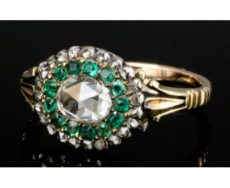 A late Victorian gold coloured metal mounted emerald and diamond ring, the central rose cut diamond approximately .50ct surro