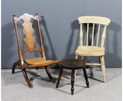 A late Victorian child's inlaid walnut and cane seated folding occasional chair, the shaped crest rail and solid vase pattern