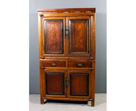 A Chinese hardwood two tier cabinet, the upper part with moulded cornice, fitted two shelves and two small drawers, enclosed 