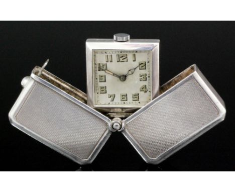 A 1920's gentleman's silver cased travelling timepiece, the square silvered dial with luminous Arabic numerals and luminous h