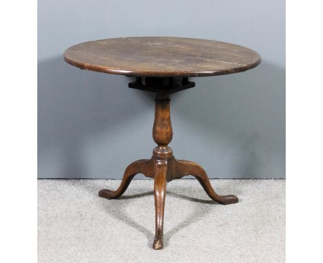 An 18th Century oak circular tripod table with plain top, on birdcage baluster turned central column and cabriole legs with p