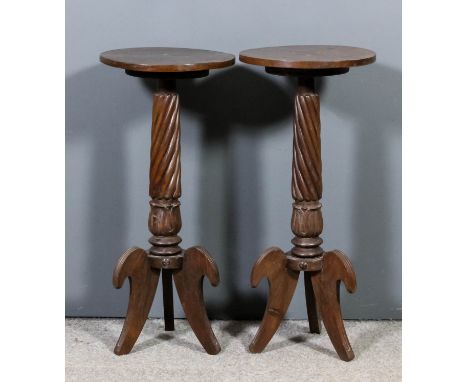 A pair of mahogany circular tripod occasional tables on turned and spiral reeded central columns and on three shaped supports