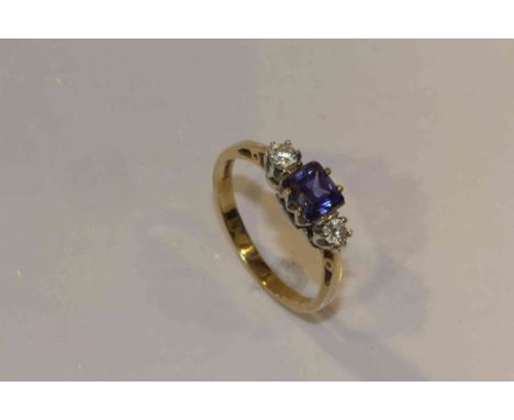 A tanzanite and diamond ring, the square cut tanzanite four claw set between two brilliant cut claw set diamonds, all set in 
