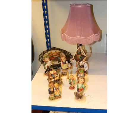 Collection of eight Hummel Goebel figures, Goebel lamp, Armani lamp and pair needleworks