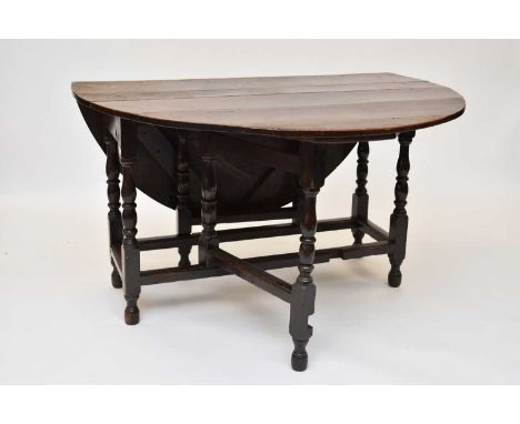 An early 18th century oak gateleg table, with an 8 plank oval top and turned supports, restorations, 126cm x 147cm x 73.5cm h