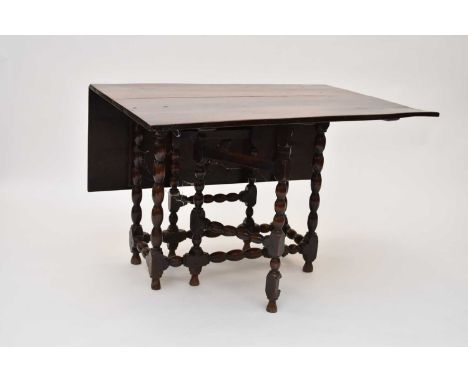 An 18th century oak gateleg table, the plain rectangular top raised on bobbin-turned supports united by bobbin-turned stretch