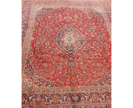 A large Persian Kashan carpet, modern, with a traditional floral pattern on a red ground, 390 x 288cmCondition report: Small 