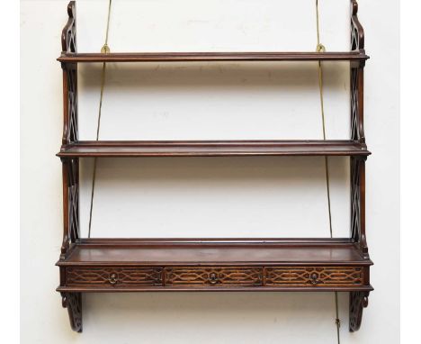 A George III style Chippendale taste waterfall wall shelf, the fretwork sides supporting three graduated shelves, the lowest 