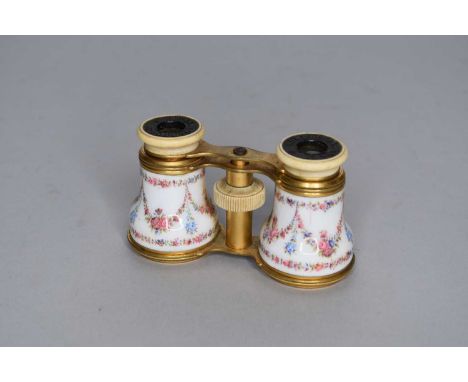 A pair of gilt metal and enamel opera glasses by Howell James &amp; Co, the barrels enamelled with floral swags, 10.5cm wide.