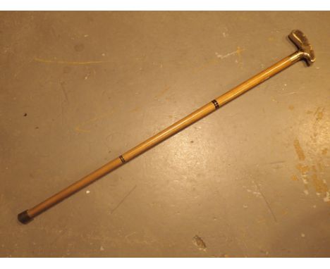 Brass handled walking stick with the grip shaped like a golf club base 