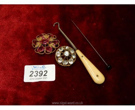 Two period costume jewellery brooches with pink and clear stones, one a/f, bone handled button hook and a hat pin.