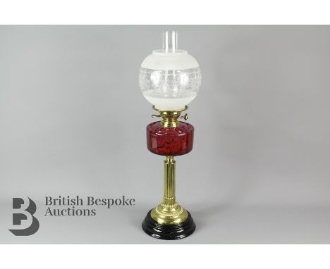 Antique Victorian oil lamp with porcelain base and corinthian column with cranberry glass reservoir shade and funnel, in good