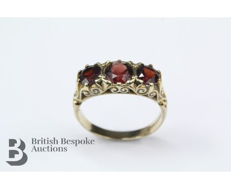 9ct yellow gold and garnet ring, the ring set with a center garnet approx 6mm flanked by two further garnets approx 5mm, Birm