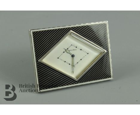 Art Deco bedside clock, with silver and enamel frame, white enamel face with baton numerals, luminescent hour and minute hand