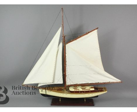 A large wooden classic yacht model sailboat AS135 by Authentic Models with three sails, detailed rigging and an anchor on a w