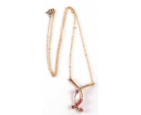 A 9ct ruby pendant, the crossover style pendant set with six small round rubies, 2.5cm long, on fine chain with clasp stamped