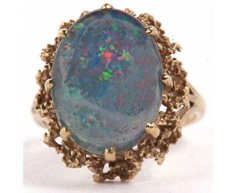 A 9ct opal triplet ring, the oval opal triplet cabochon, claw mounted with textured metal surround, with plain band stamped 3