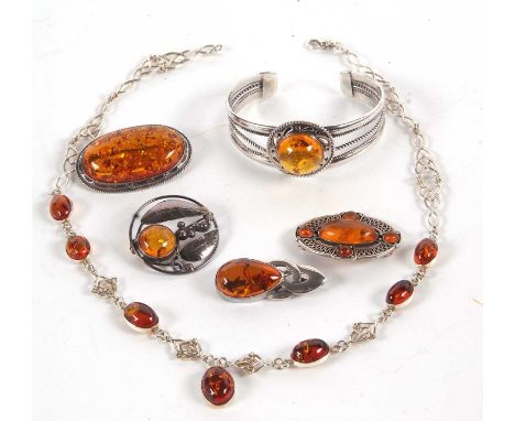 A quantity of Celtic style and other amber jewellery to include an oval amber cabochon and knotwork necklace, a silver bangle