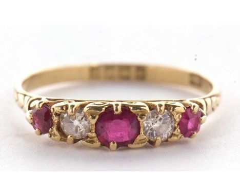 An early 20th century 18ct ruby and diamond ring, the alternating round, graduated rubies and diamonds, with scrolled gallery