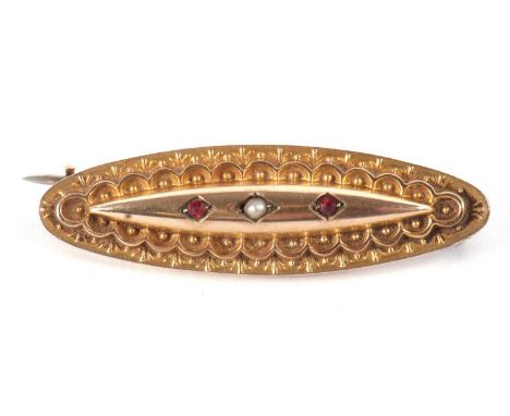 A 9ct bar brooch, the navette shape brooch set to centre with a single seed pearl and a red hardstone to either side, with gl