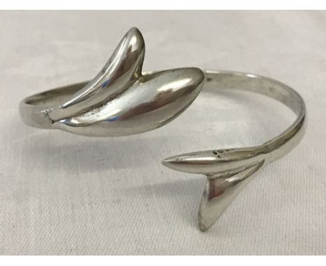A white metal fish tail bangle with Arabic Hallmarks.  