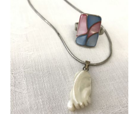 A mother of pearl foot shaped pendant on a silver rope chain. Together with a silver shell set ring. 