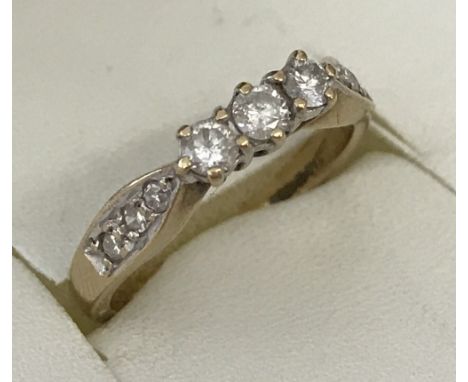 A 9ct gold and diamond trilogy ring. 3 trilogy diamond .07 ct each with each shoulder set with 3 diamond .02 ct each. Size K 