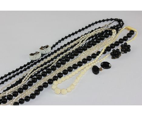 An ivory bead necklace, a black onyx bead necklace and ear studs, freshwater pearl necklace, a jet necklace and ear studs 