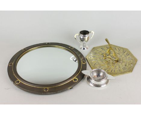 A brass sundial,19cm, a small silver plated trophy, a tea strainer on stand and a convex circular wall mirror, 30cm