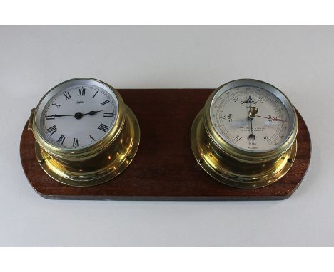 A Sestrel brass cased 'porthole' clock and barometer mounted on mahogany panel