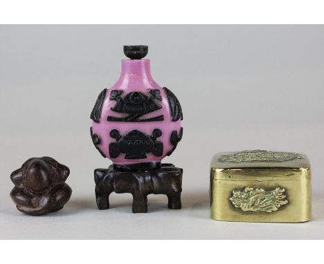 A Chinese small brass box with decorated panels, a Chinese snuff bottle, a carved wood figure and a small wooden stand