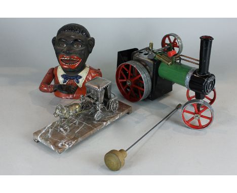 A Mamod steam engine, a black man cast iron money box and a metal horse and coach ornament